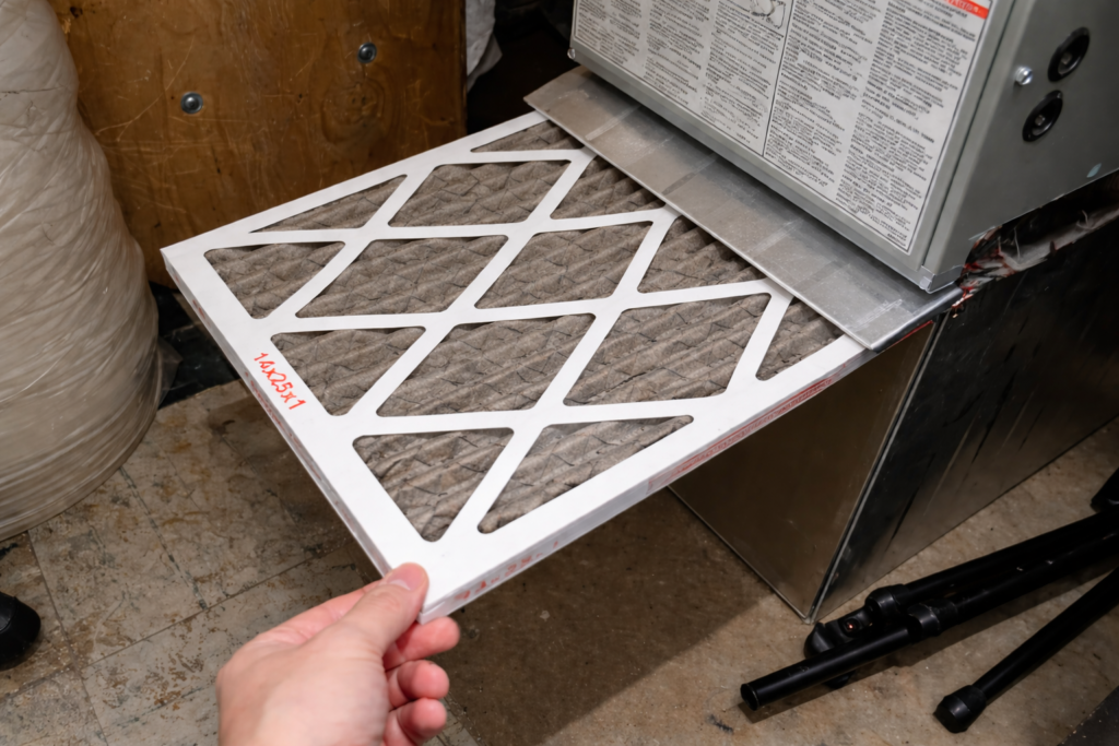 replacing_furnace_filter Image of a homeowner replacing their dirty furnace filter.