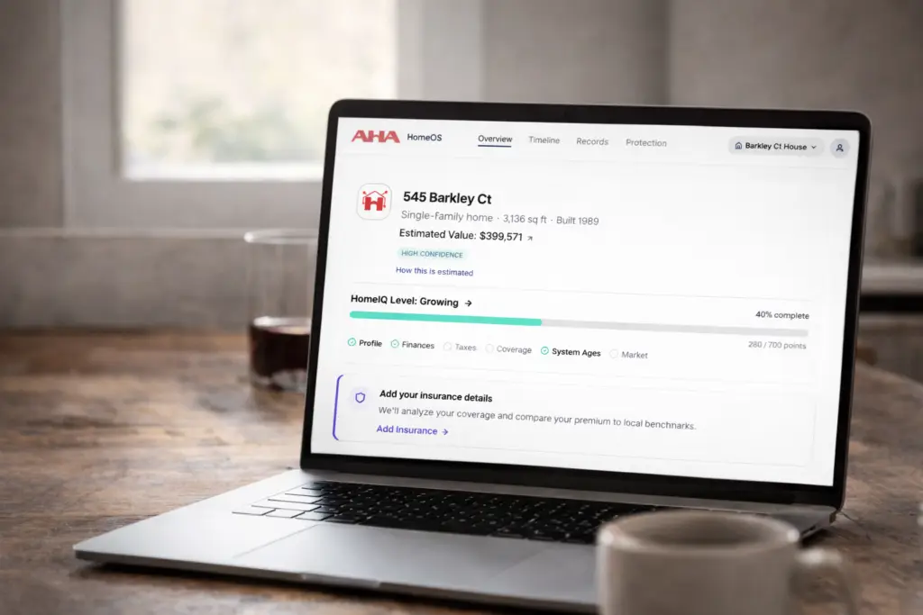 Laptop displaying a home management dashboard with property value, maintenance alerts, and financial insights.
