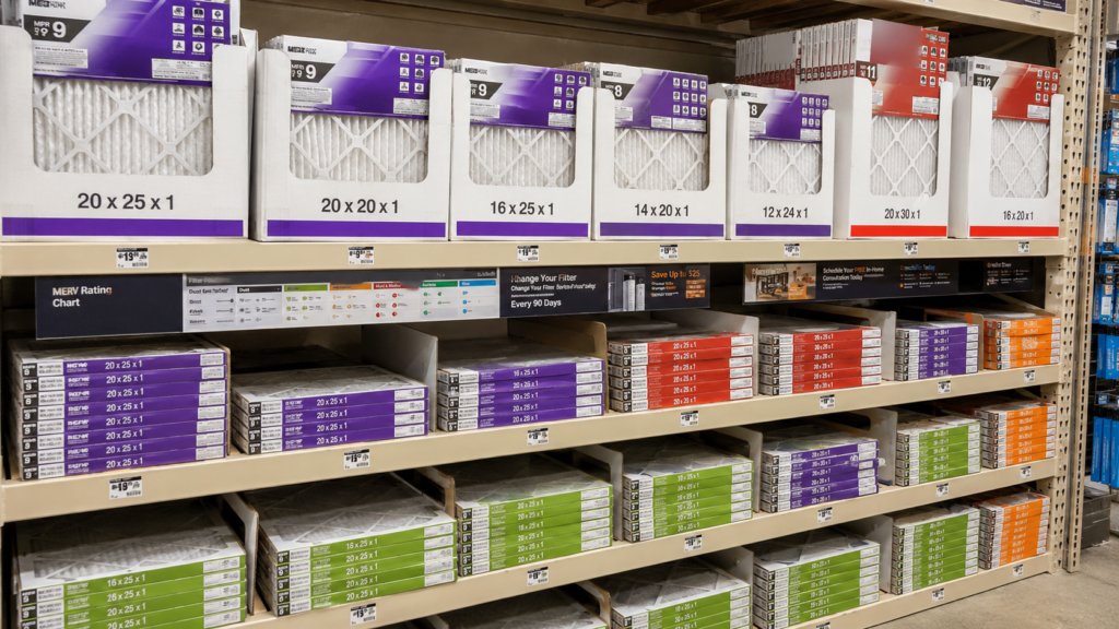 HVAC air filters in multiple sizes and MERV ratings displayed in a home improvement store aisle.